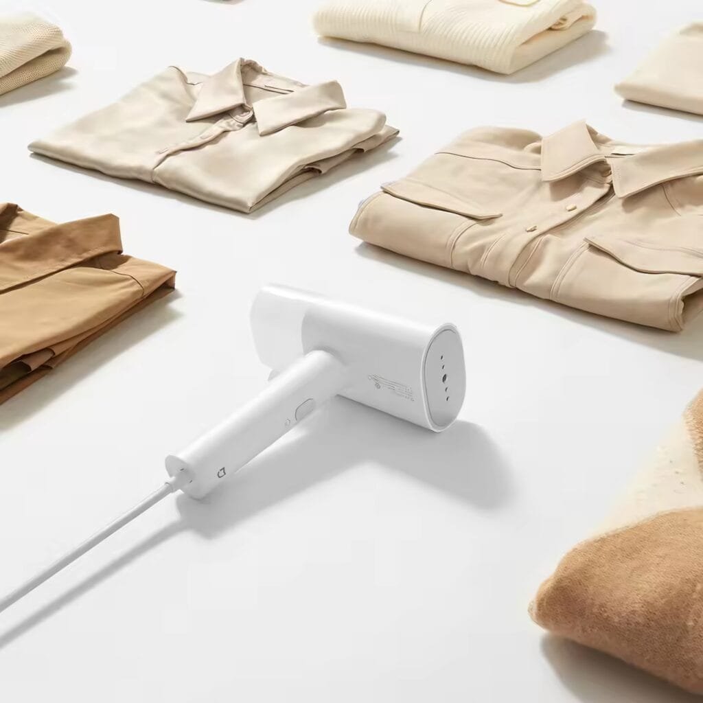 Xiaomi Mijia Handheld Garment Steamer 2 Review: Compact white design placed next to folded ironed shirts