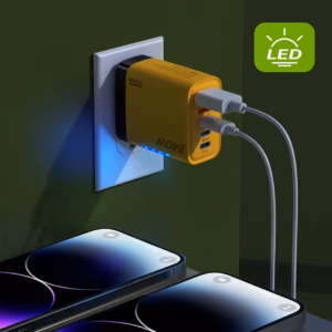 240W GaN charger plugged into wall outlet charging two smartphones with LED indicator