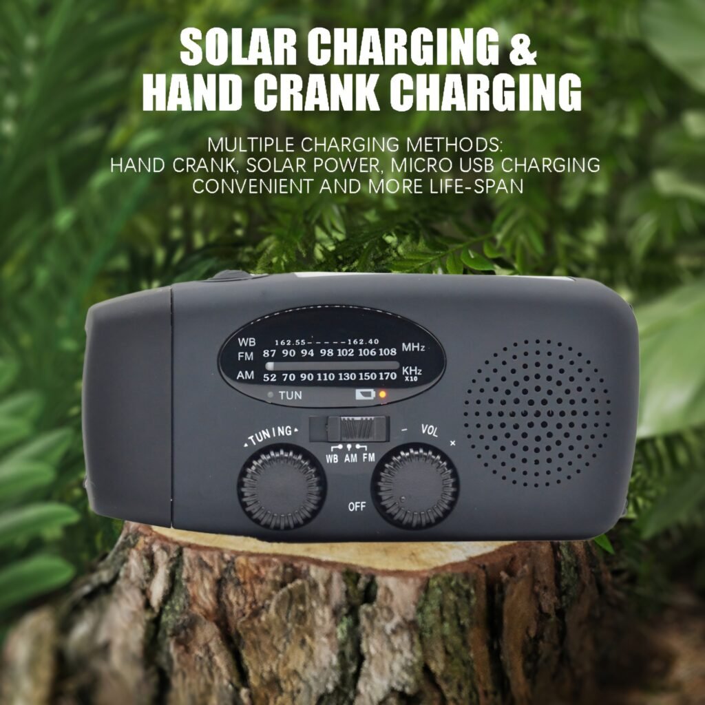 Black portable solar crank radio sitting on wood showing hand crank charging feature
