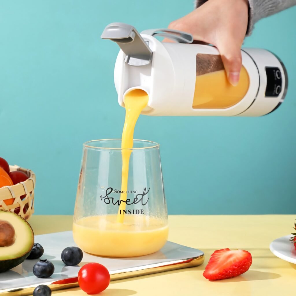 Pouring fresh orange juice from the portable blender cup into a glass