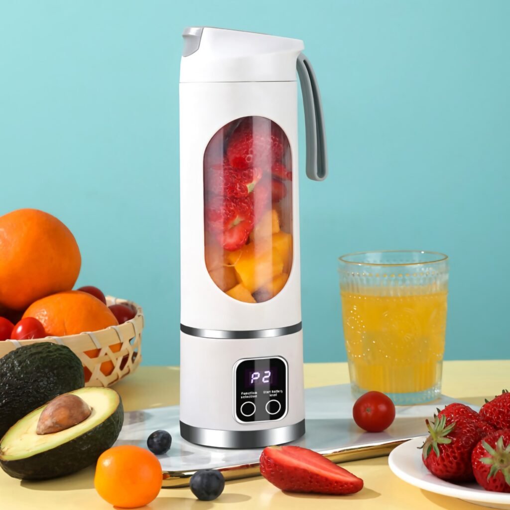 White portable blender standing on a table filled with blended strawberry smoothie
