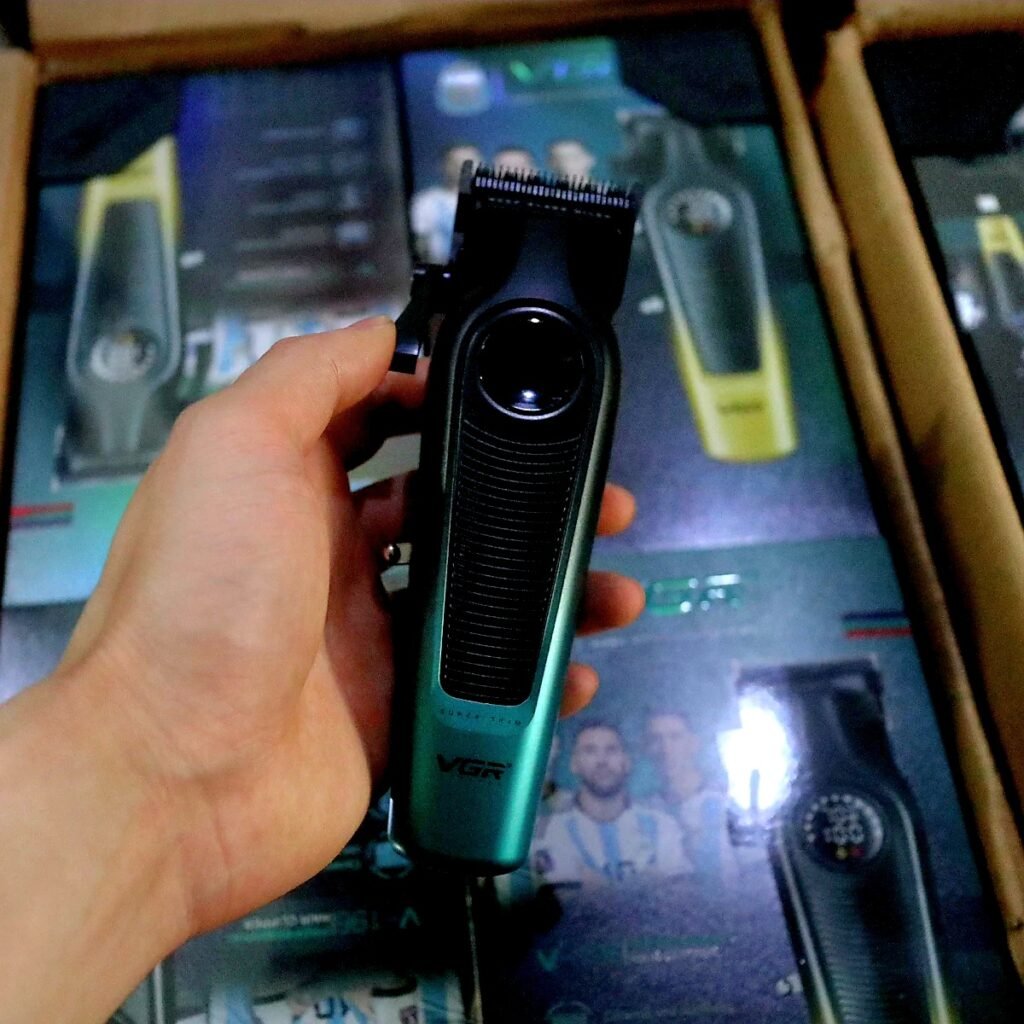 Hand holding VGR 196 Professional Hair Clipper showing side adjustment lever