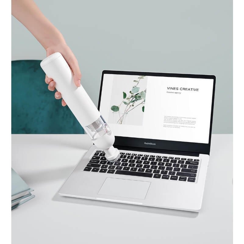 Cleaning a laptop keyboard with Xiaomi Mijia Portable Handheld Vacuum Cleaner.