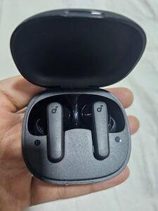 Soundcore R50i review earbuds inside charging case held in hand