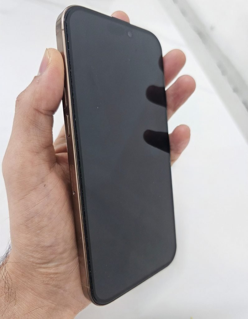 iPhone 16 Pro Max held in hand showing front display and slim bezels